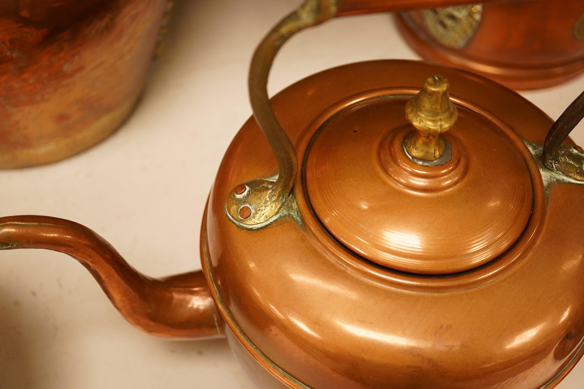 Four various copper vessels and a brass teapot, tallest 47cm